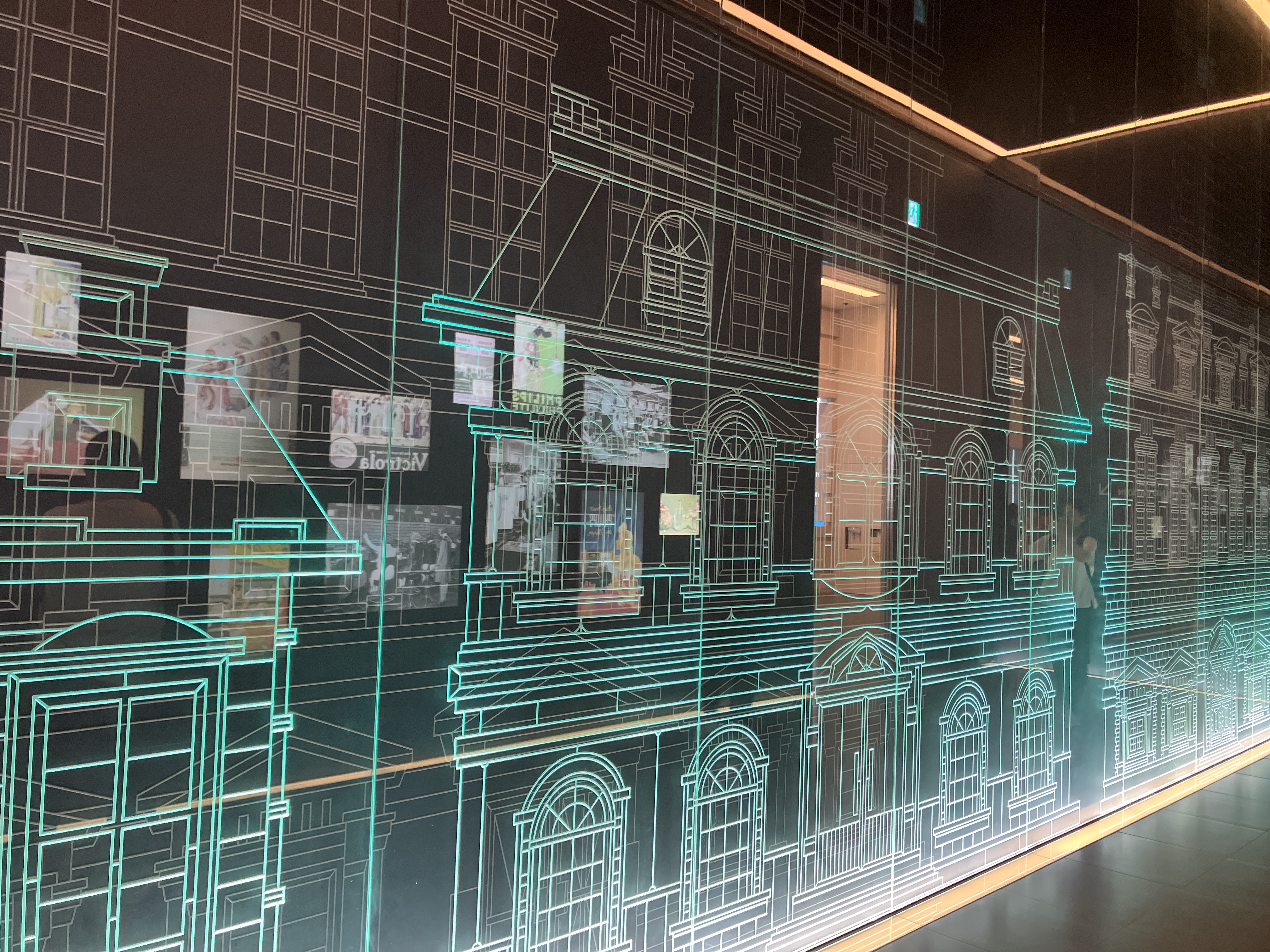 建築物の線画が発光する展示を見学する参加者