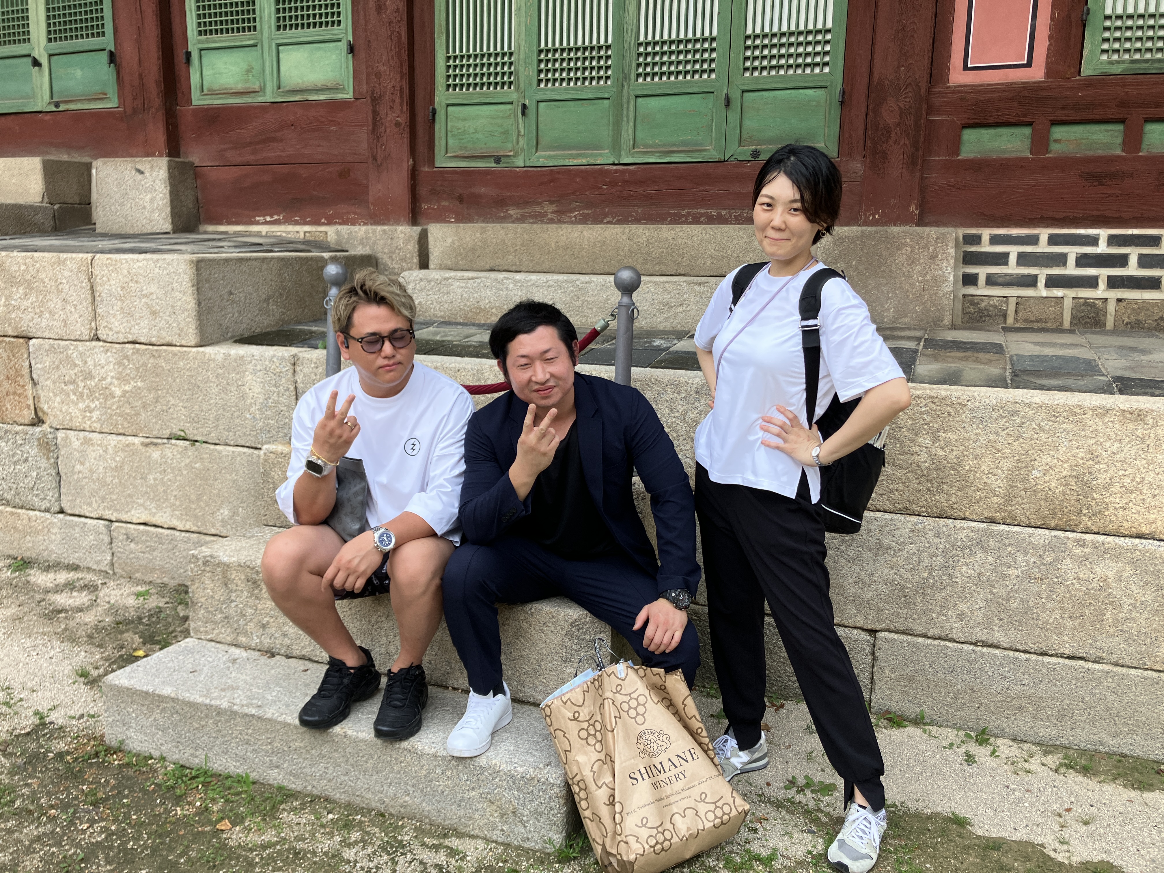 韓国の伝統建築の前で撮影した文化視察参加者3人の記念写真